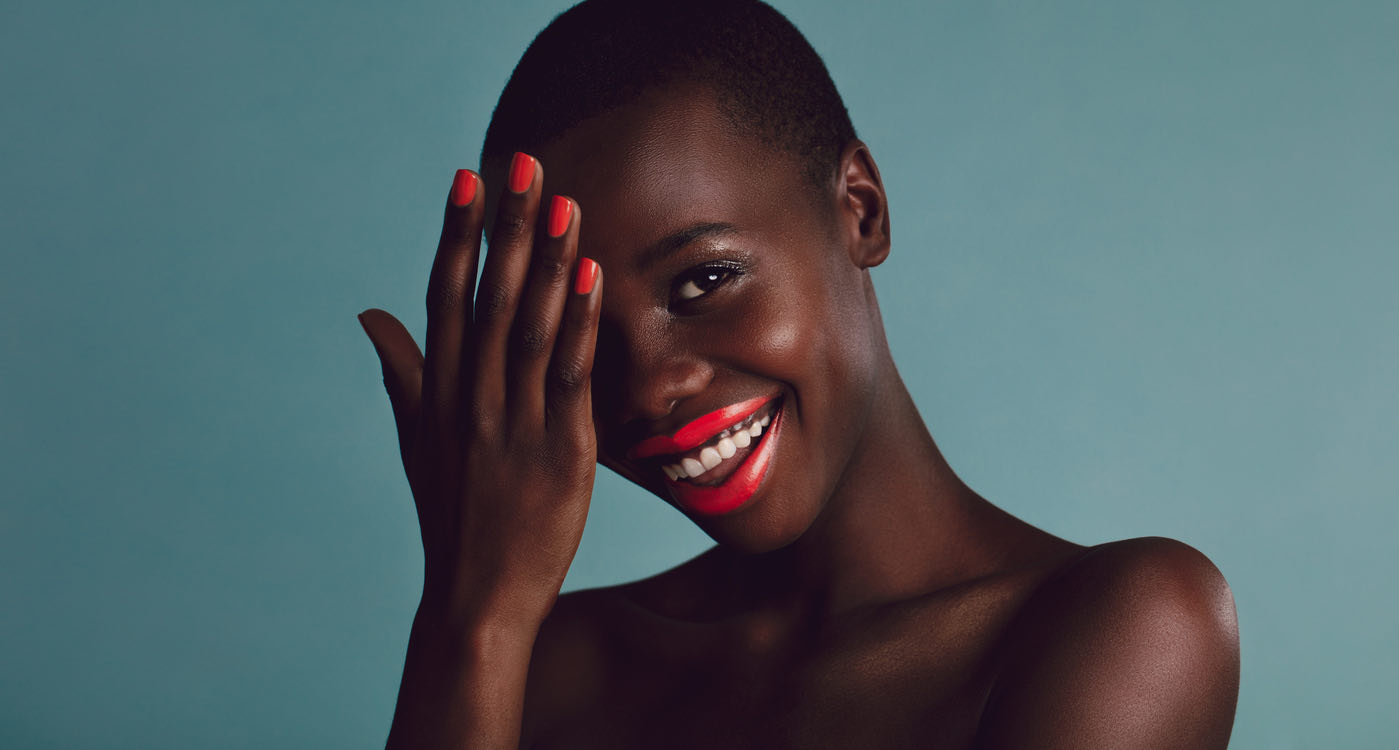 Smiling South African woman with freshly done red nails and bold lipstick
